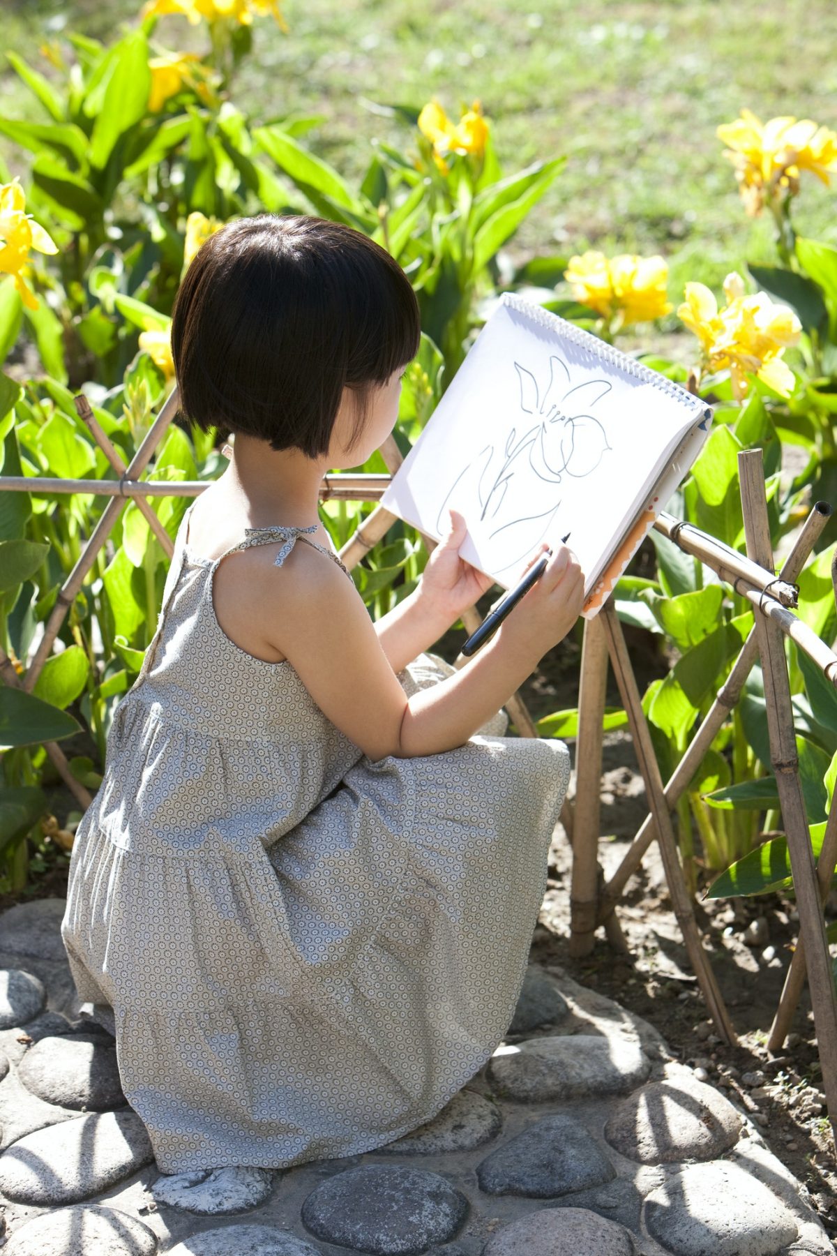 Little girl painting in garden