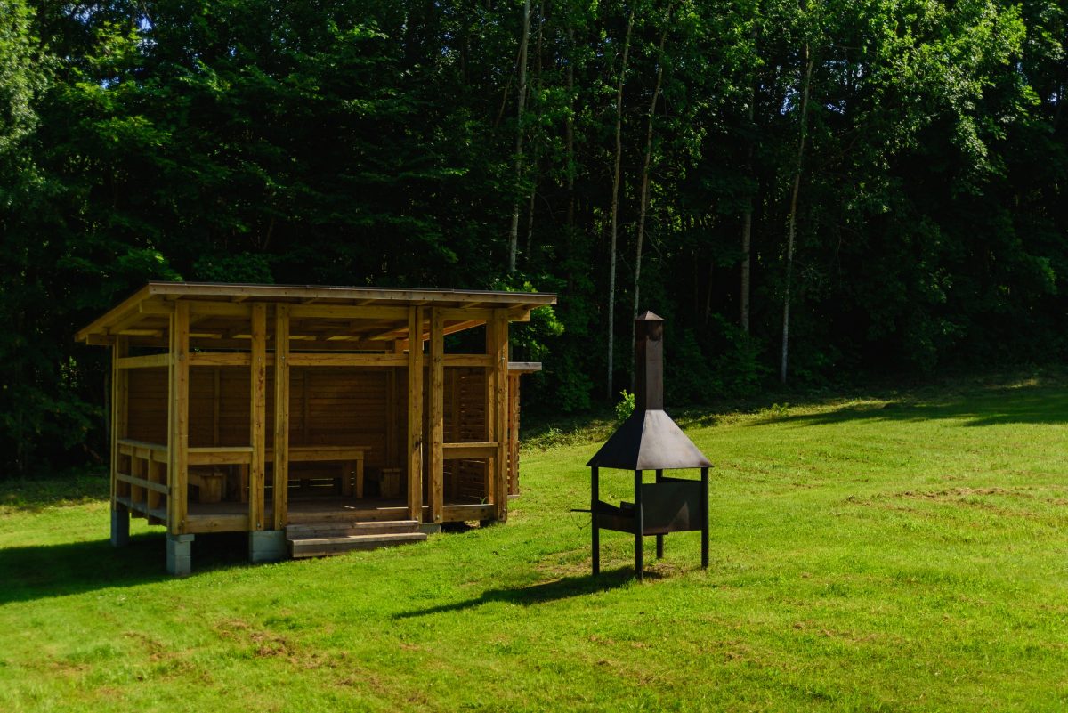 Wooden pavilion with fireplace for bbq on backyard